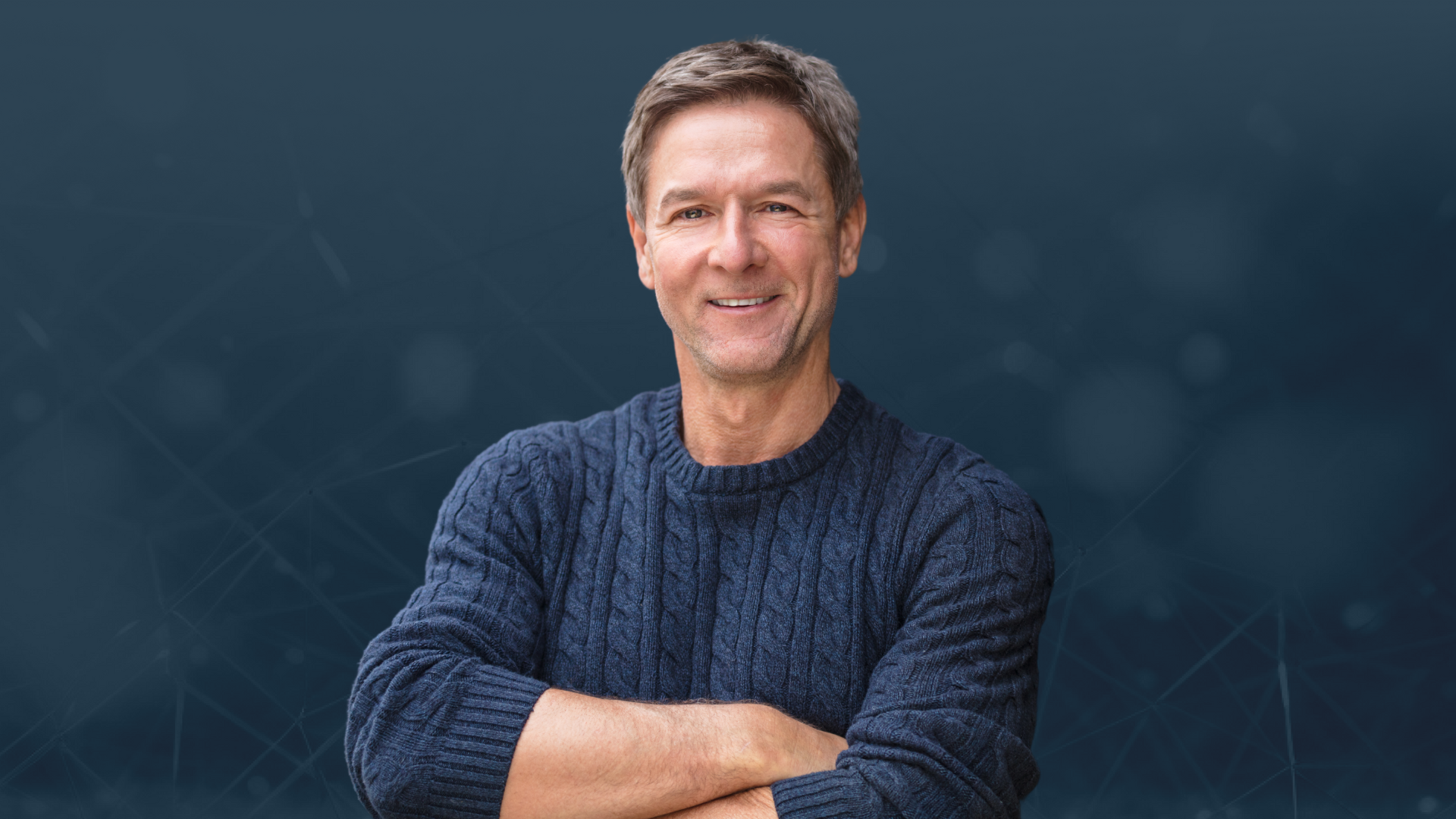 Man wearing a blue sweater against a dark background