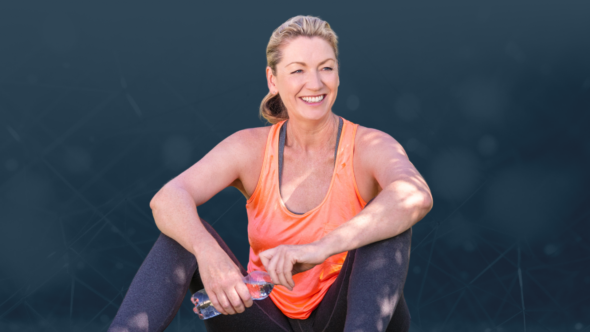 Woman in athletic wear sitting on a dark background